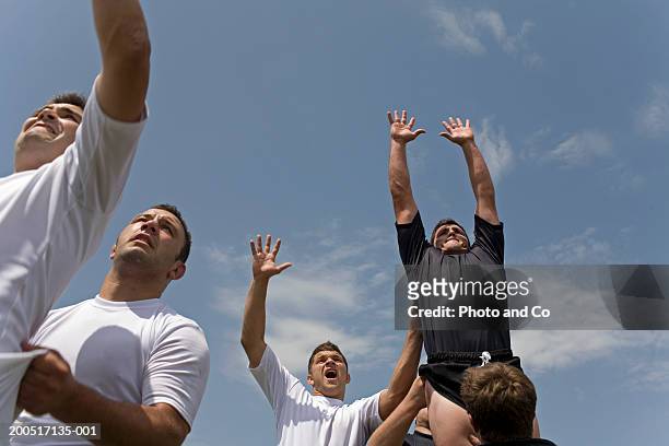 rugby players reaching for ball, low angle view - althete bildbanksfoton och bilder