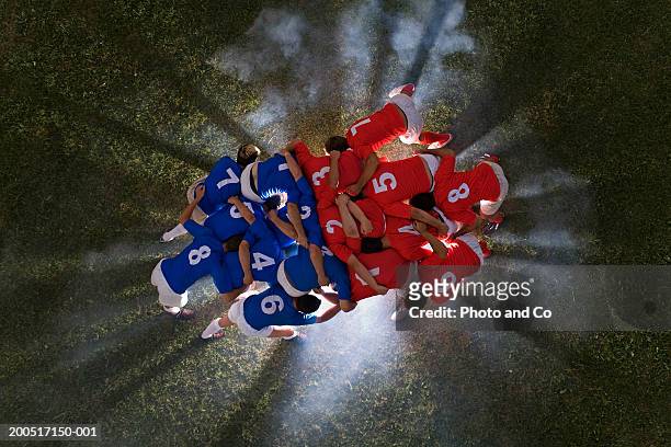 rugby players in scrum, light emanating from ground, overhead view - althete fotografías e imágenes de stock