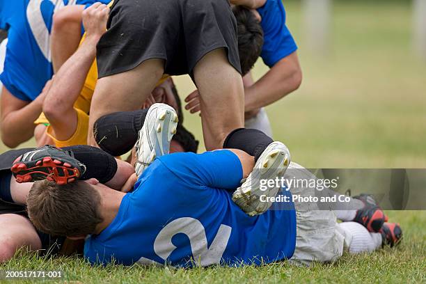 rugby players tackling on pitch - rugby tackle stockfoto's en -beelden