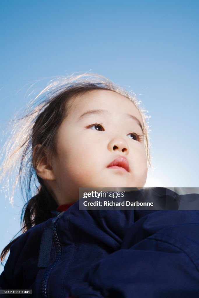 Girl (2-4) outdoors, looking away, low angle view