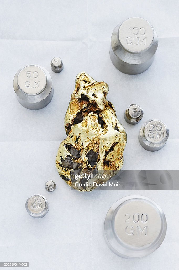 Gold nugget and scale weights, overhead view, close-up