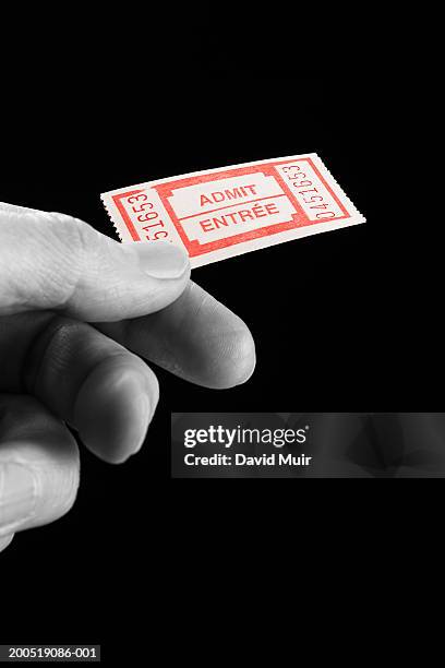 mature man holding admit one ticket, close-up of hand, (b&w) - admit one frase corta fotografías e imágenes de stock