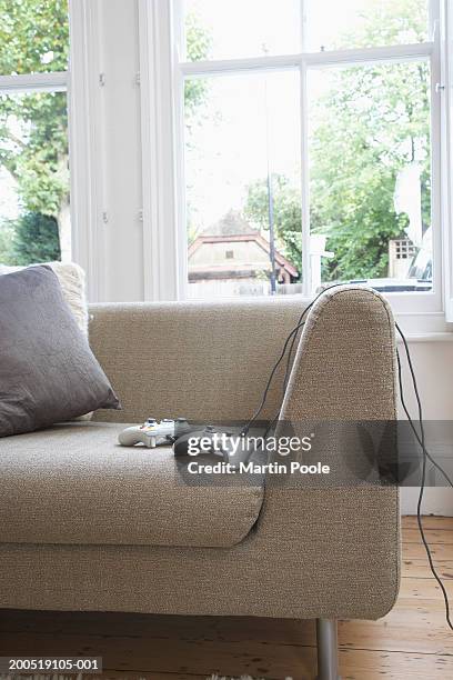 computer game consols on sofa in living room - game controller stock pictures, royalty-free photos & images