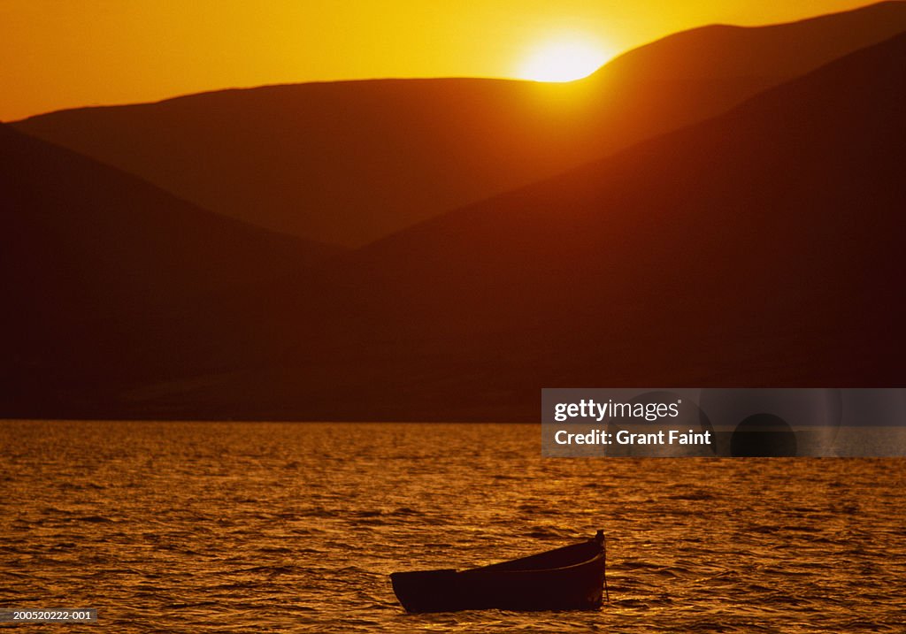 Ireland, Kerry, rowing boat on lake, sunset