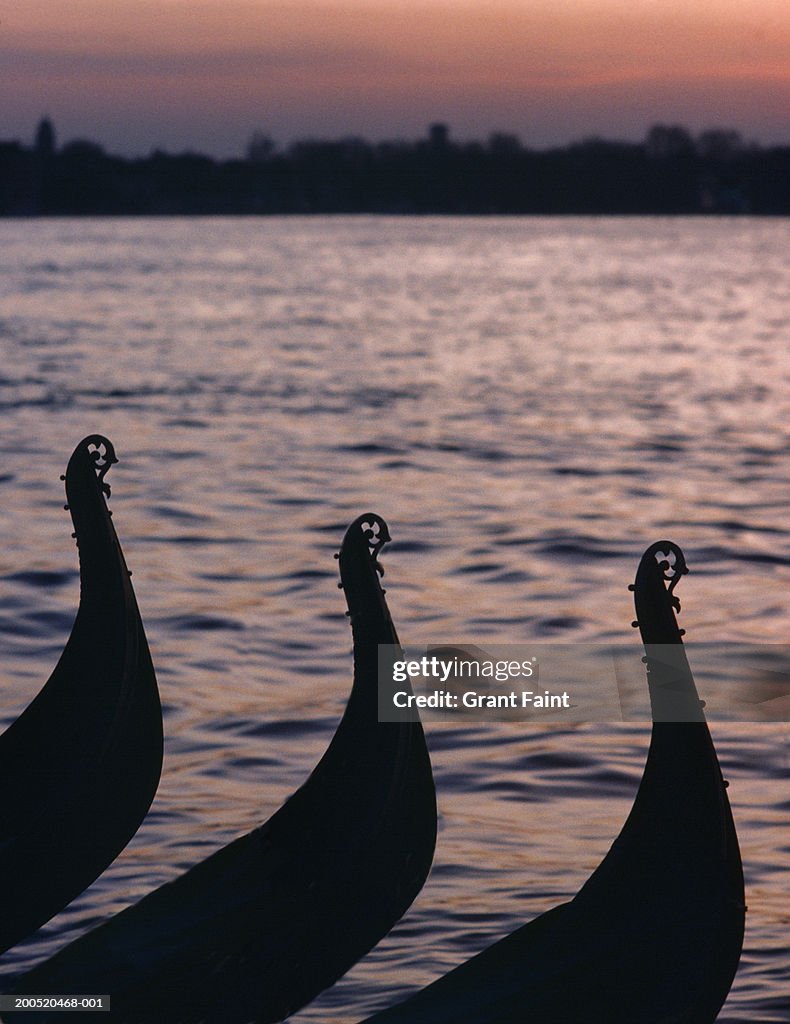 Italy, Venice, silhouettes of gondola bows, dawn