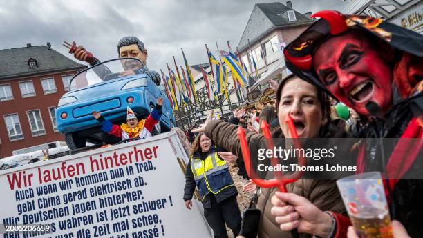 Parade float shows an effigy of Chinese President Xi Jinping pulling the plug on an electric car and leaving German carmakers behind at the annual...