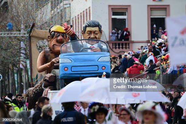 Parade float shows an effigy of Chinese President Xi Jinping pulling the plug on an electric car and leaving German carmakers behind at the annual...