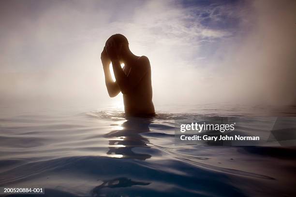 silhouette of person in geothermal lagoon - thermal pool stock pictures, royalty-free photos & images