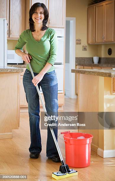 mature woman mopping kitchen floor, smiling, portrait - kitchen mop stock pictures, royalty-free photos & images