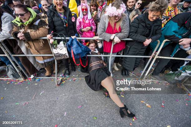 Young woman tries to pull sweets thrown from the carnival floats towards her with her feets at the annual Rose Monday Carnival parade on February 12,...