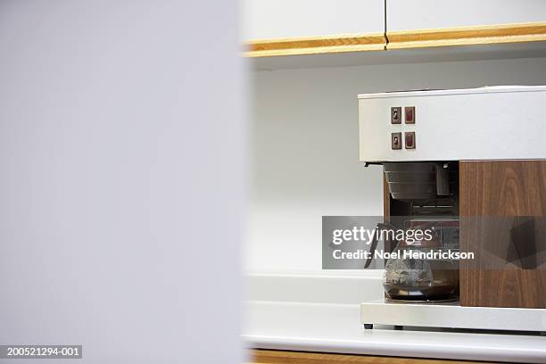 pot of coffee brewing on automatic drip machine, focus on coffee pot - koffiepot stockfoto's en -beelden