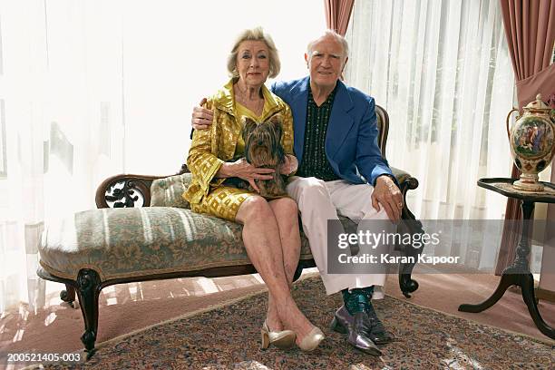 senior couple sitting on sofa, with dog, smiling, portrait - diva papel humano - fotografias e filmes do acervo