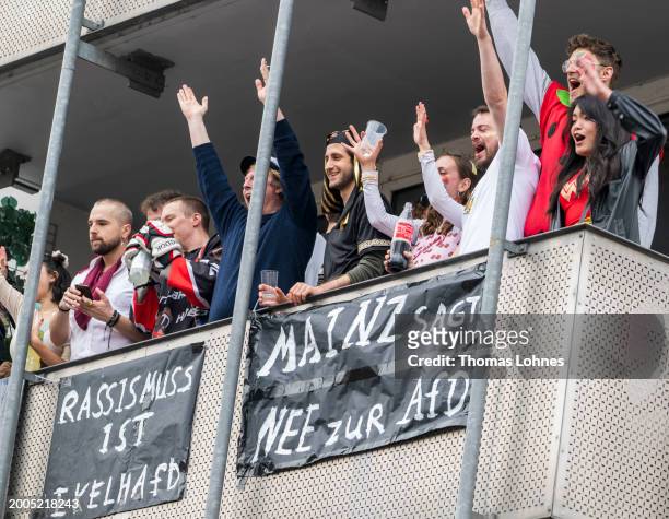 Spectators celebrate on balconies with banners 'Against Racism and Mainz says NO to the AfD' at the annual Rose Monday Carnival parade on February...