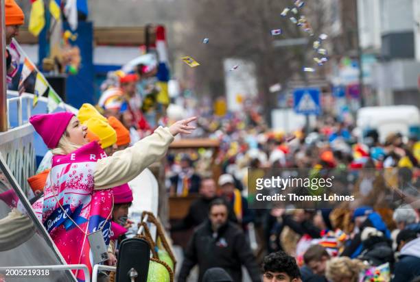 Young woman throws sweets from a parade float at the annual Rose Monday Carnival parade on February 12, 2024 in Mainz, Germany. The Mainz and...