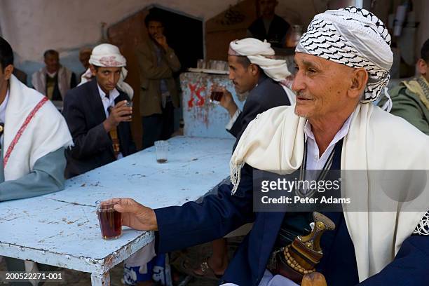 yemen, san'a province, senior man drinking tea, smiling - yemen people stock pictures, royalty-free photos & images