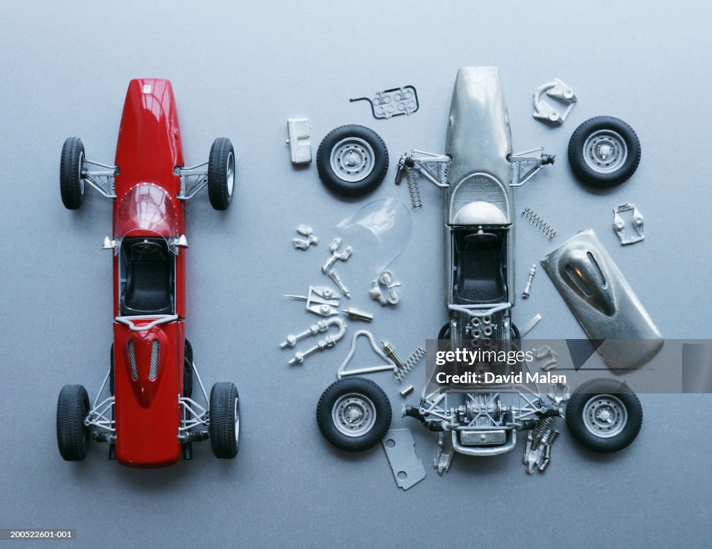 Two toy cars, one assembled, one in pieces, close-up, overhead view