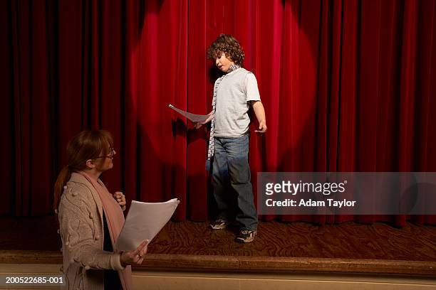 female teacher and boy (10-12) standing on stage rehearsing - acteren stockfoto's en -beelden