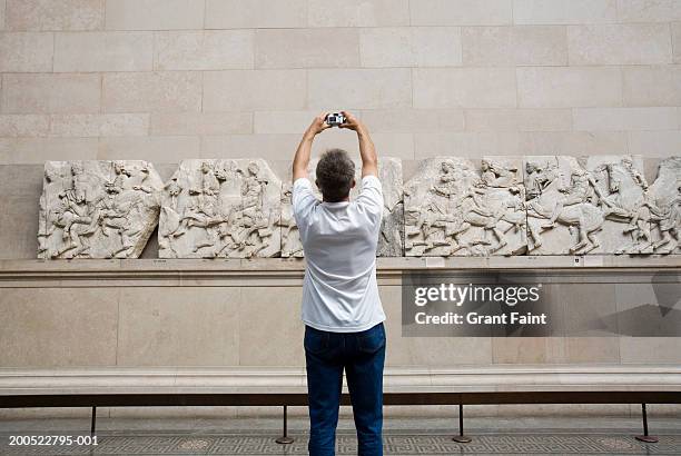 england, london, british museum, mature man taking photo of carving - the chronicles of narnia the lion the witch and the wardrobe london premiere stockfoto's en -beelden