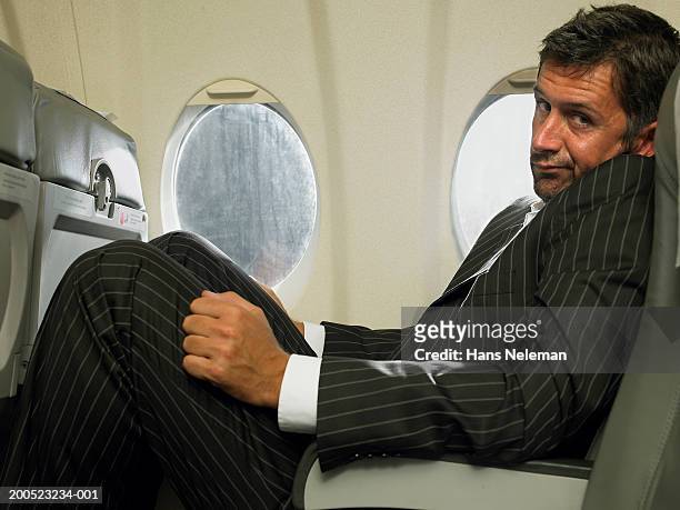 businessman sitting in passenger seat of aero plane, portrait - crowded plane stock pictures, royalty-free photos & images