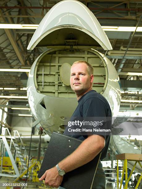 engineer with laptop in front of aircraft in hangar, portrait - aerospace engineer ストックフォトと画像