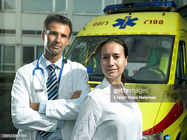 male doctor and nurse standing near ambulance outside hospital, portrait - hospital exterior stock pictures, royalty-free photos & images