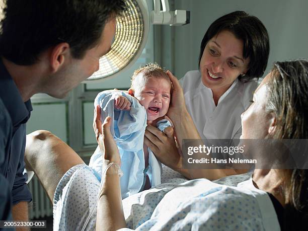 midwife and parents with baby (0-6 months) in hospital - midwifery stock-fotos und bilder