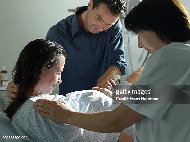 midwife and husband supporting pregnant woman, giving birth in hospital - midwifery stock-fotos und bilder