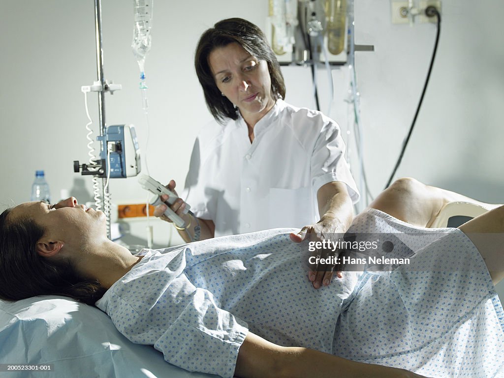 Midwife checking woman's pregnancy in hospital