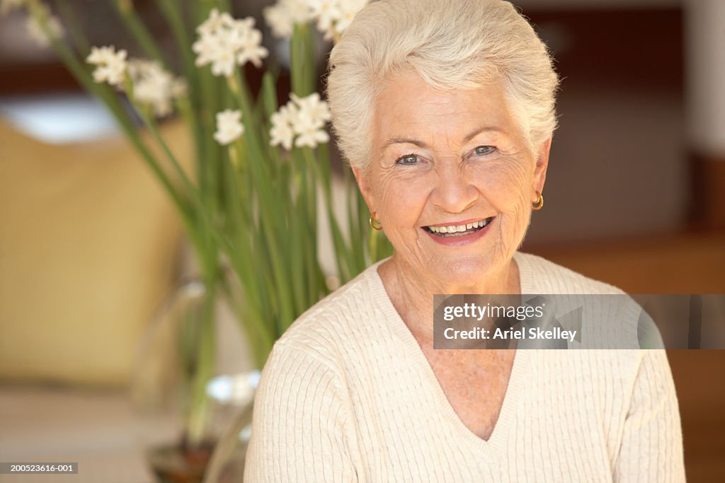 Senior woman in front of flowers, portrait