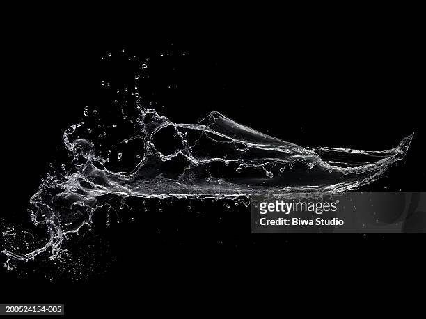 splash of water on black background - splash photos et images de collection