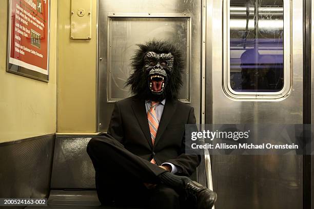 man in gorilla mask on the train - animal oddity stock pictures, royalty-free photos & images