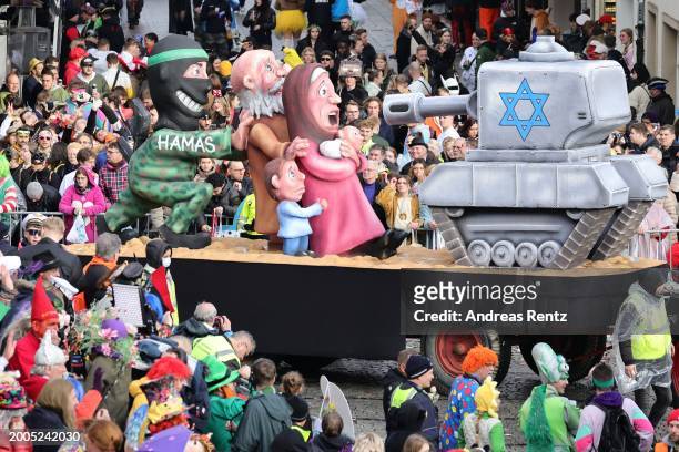 Parade float shows an effigy of a Hamas activist pushes a family in front of an Israeli tank at the annual Rose Monday Carnival parade on February...