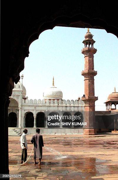 Two employees of the Moti Masjid mosque clean the ground in Bhopal, 05 November 2002, on the eve of Ramadan, the Islamic month of fasting. Ramadan is...