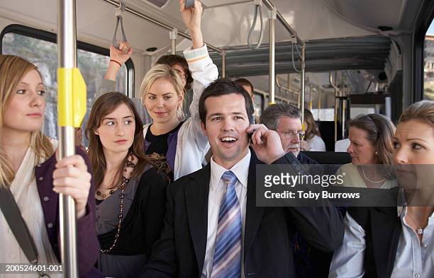 businessman using mobile phone, laughing on bus - people on buses stockfoto's en -beelden
