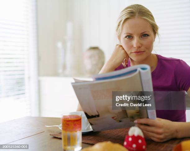 woman holding magazine at table, portrait - glass magazine stock pictures, royalty-free photos & images