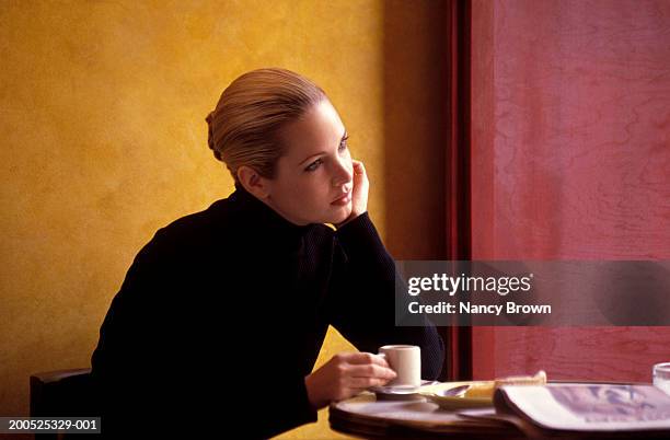 young woman sitting in cafe, side view - leaning on elbows stock pictures, royalty-free photos & images