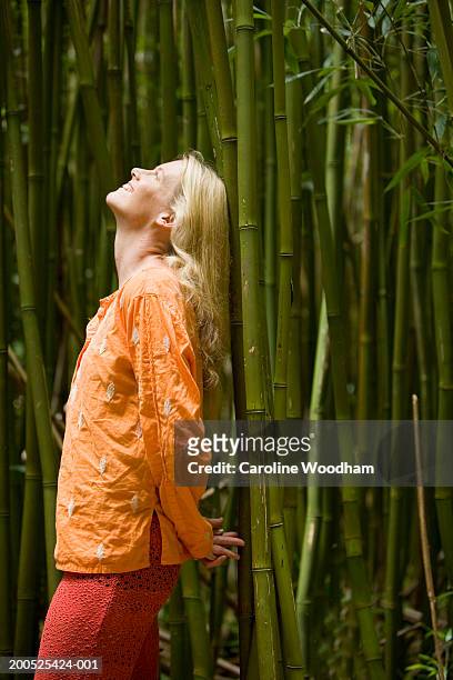 woman practicing yoga in bamboo forest, side view - women practice yoga in the bamboo forest stockfoto's en -beelden
