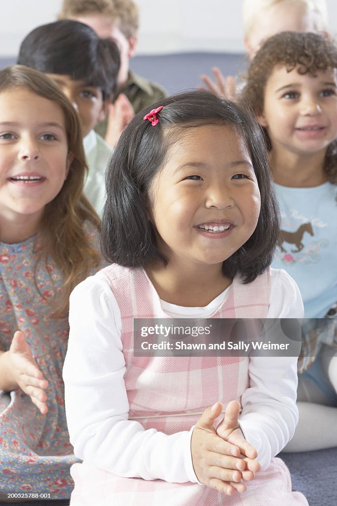 Group of children (5-7) clapping and smiling