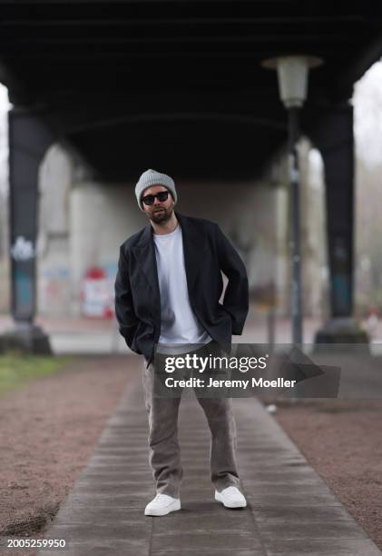 Benjamin Beyer aka David Puentez seen wearing Jacques Marie Mage black sunglasses, grey wool knit beanie hat, white cotton t-shirt, dark grey checked...