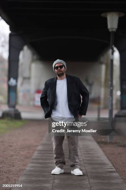 Benjamin Beyer aka David Puentez seen wearing Jacques Marie Mage black sunglasses, grey wool knit beanie hat, white cotton t-shirt, dark grey checked...