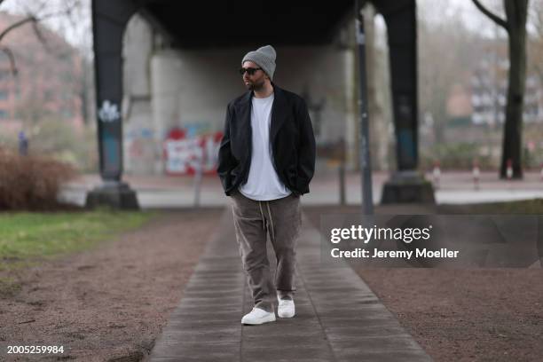 Benjamin Beyer aka David Puentez seen wearing Jacques Marie Mage black sunglasses, grey wool knit beanie hat, white cotton t-shirt, dark grey checked...