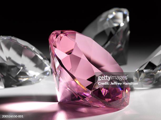 large pink diamond surrounded by clear diamonds, close-up (still life) - diamond gemstone stock pictures, royalty-free photos & images