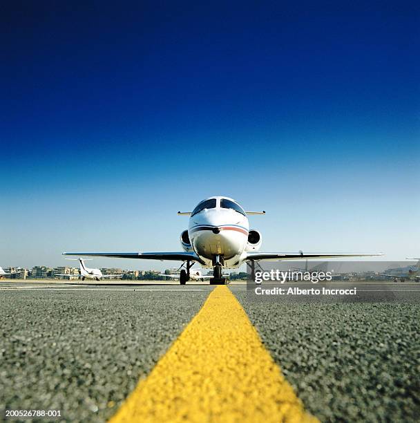 private jet aircraft on tarmac - linea gialla foto e immagini stock