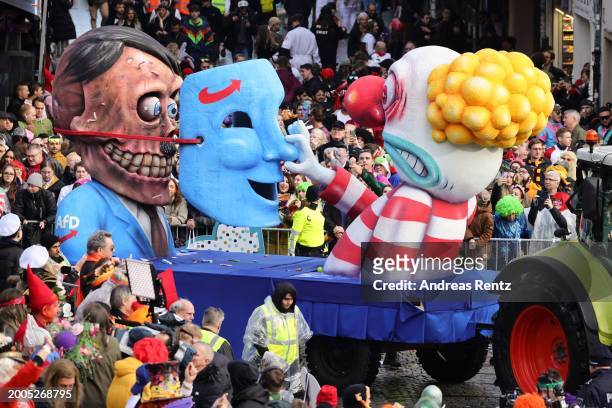 Parade float shows an effigy of Adolf Hitler being unmasked as a carnival member pulls his right-wing party AfD mask away at the annual Rose Monday...
