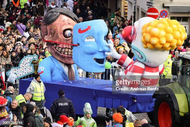 Parade float shows an effigy of Adolf Hitler being unmasked as a carnival member pulls his right-wing party AfD mask away at the annual Rose Monday...