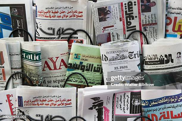 newspapers for sale in rack, close up - westers schrift stockfoto's en -beelden