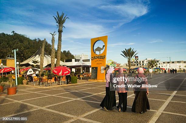 morocco, agadir, three muslim women walking along promenade, rear view - agadir stock pictures, royalty-free photos & images