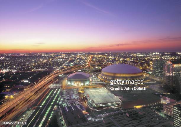 usa, louisiana, new orleans, street and super dome illuminated at dusk - new orleans fotografías e imágenes de stock