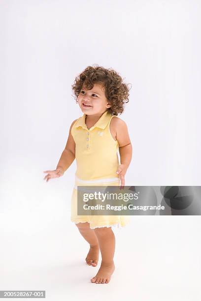 girl (21-24 months) wearing yellow dress, smiling - one baby girl only foto e immagini stock