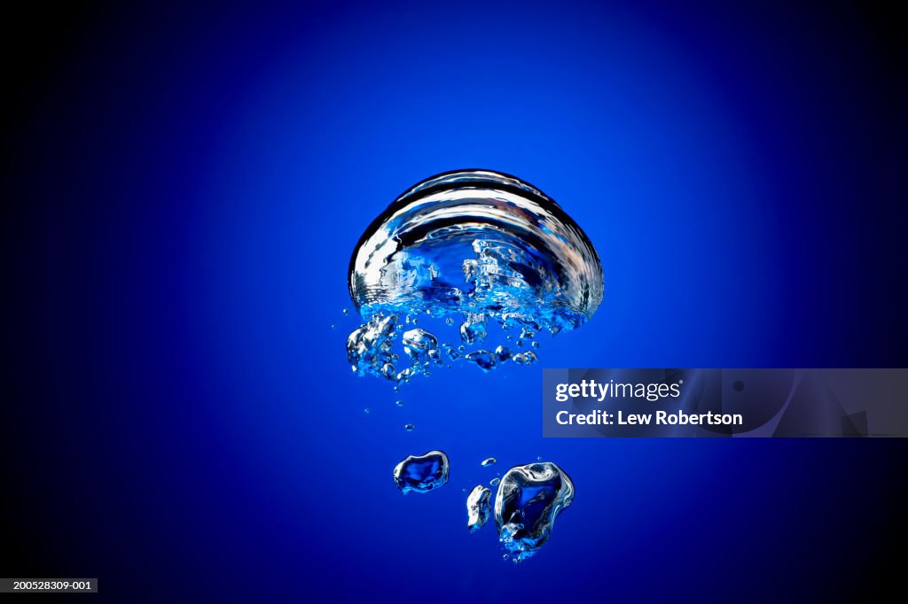 Bubbles in water, against blue background, (blurred motion)